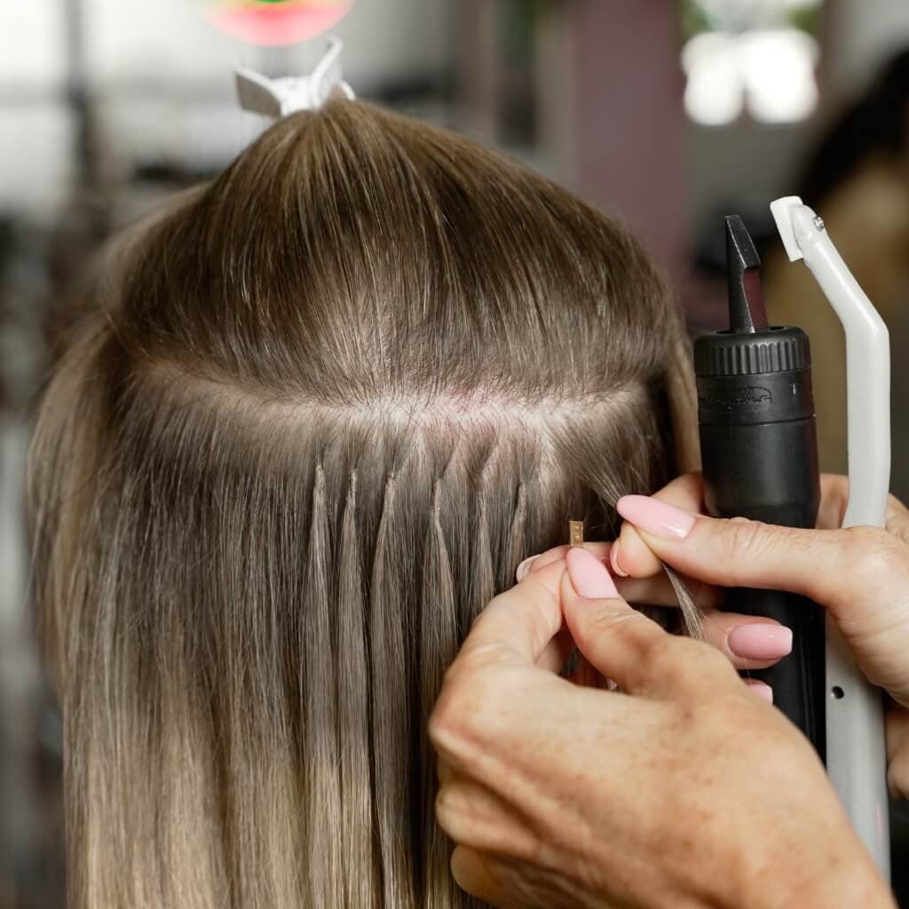 Bonded hair extensions being applied